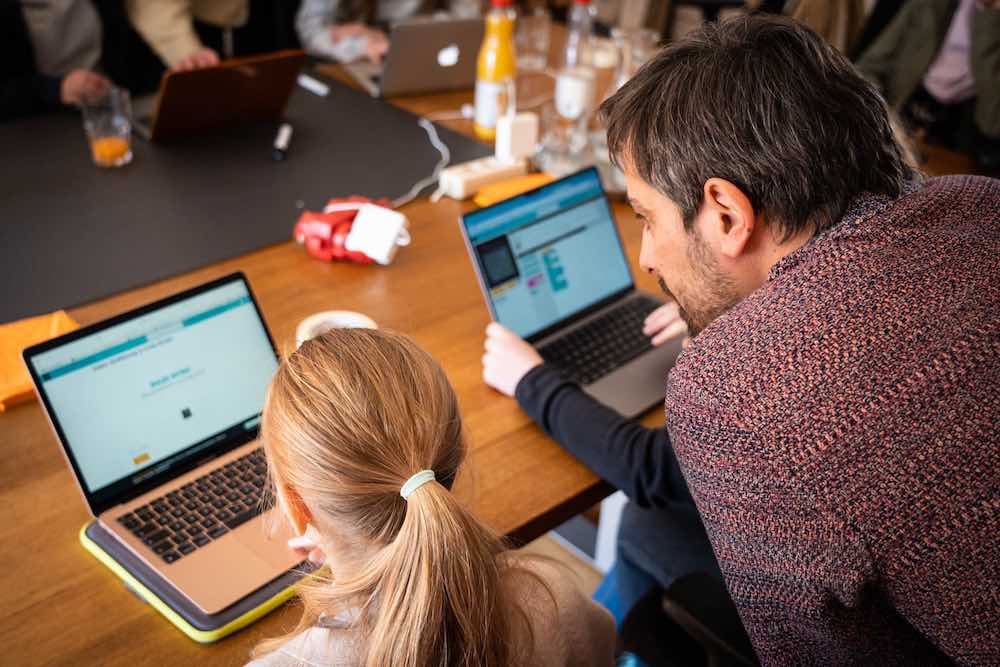 Matthias betreut zwei Schülerinnen mit Notebooks beim Girls'Day