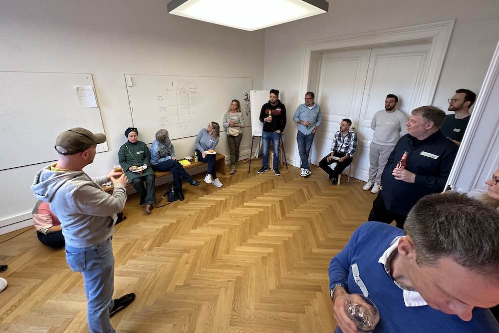Ein gutes Dutzend Teilnehmer des Scrumtischs stehen im Kreis bei der Eröffnung des Scrumtischs in unserem Lab